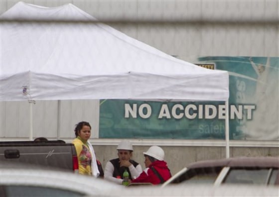 Employees of Americold Logistics are seen in a break tent outside the plant in Crete, Neb. on Thursday. A man shot and wounded three people at the cold-storage facility where he worked before apparently shooting and killing himself, authorities said. Saline County Sheriff Alan Moore told the Lincoln Star Journal that about 35 people were at the facility when the gunman opened fire at about 10 p.m. Wednesday. 
